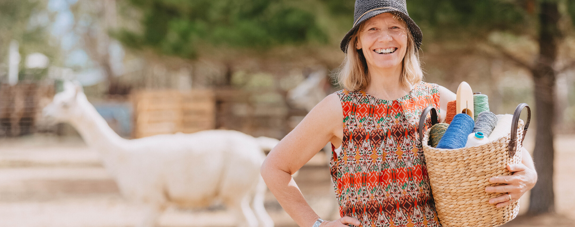 Fiona from Ashculme Textiles with an alpaca in the background