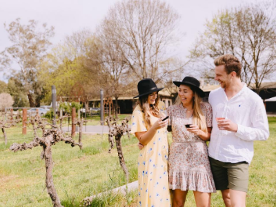 Friends enjoying wine in the sunshine at a vineyard in Wagga Wagga  